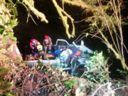 Seventeen firefighters worked to free the driver of a pickup that crashed down a 50-foot embankment Sunday night.