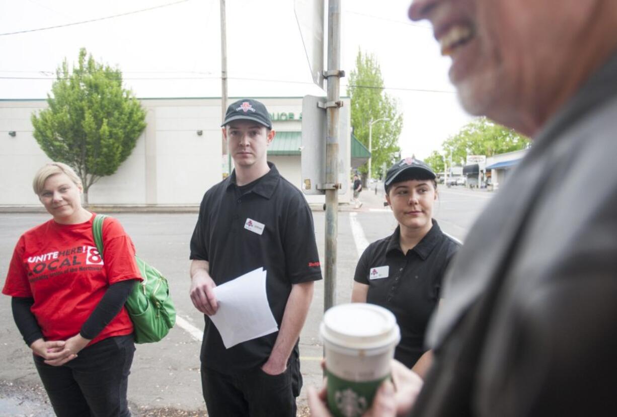 Burgerville employees Jordan Vaandering, second left, and Eli Fishel, second right, Jennifer Graham, left, and the Rev. David Wheeler of Portland&#039;s First Baptist Church visited Burgerville headquarters in downtown Vancouver to bring demands to management for $5 an hour raises and improved health care benefits for workers. The visit coincided with a union-backed rally at a Burgerville in Southeast Portland.