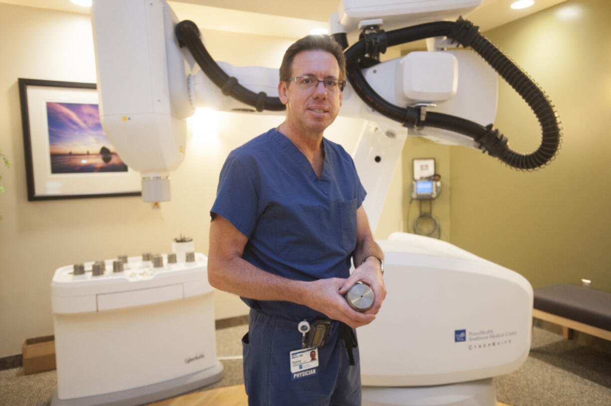 Dr. Michael Myers, a radiation oncologist at PeaceHealth Southwest Medical Center, holds a tungsten collimator with which the &quot;cyberknife&quot; machine in the background &quot;paints&quot; cancerous areas with radiation. Myers has treated 16 prostate cancer patients with the cyberknife, all of whom went into remission with no recurrences.