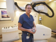 Dr. Michael Myers, a radiation oncologist at PeaceHealth Southwest Medical Center, holds a tungsten collimator with which the &quot;cyberknife&quot; machine in the background &quot;paints&quot; cancerous areas with radiation. Myers has treated 16 prostate cancer patients with the cyberknife, all of whom went into remission with no recurrences.