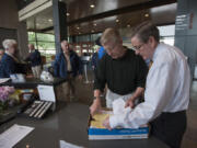 Former Vancouver Mayor Bruce Hagensen, second from right, and City Clerk Lloyd Tyler, right, look through a box of signed petitions Thursday at City Hall. The petition seeks to let voters decide whether the Vancouver City Council&#039;s pay hikes should be rescinded.