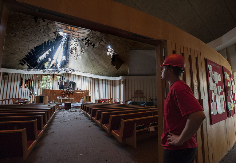 Adam Monfort, a restoration technician for Belfor Property Restoration, looks over damage to the sanctuary First Congregational United Church of Christ as crews work at the building Thursday morning, May 26, 2016.