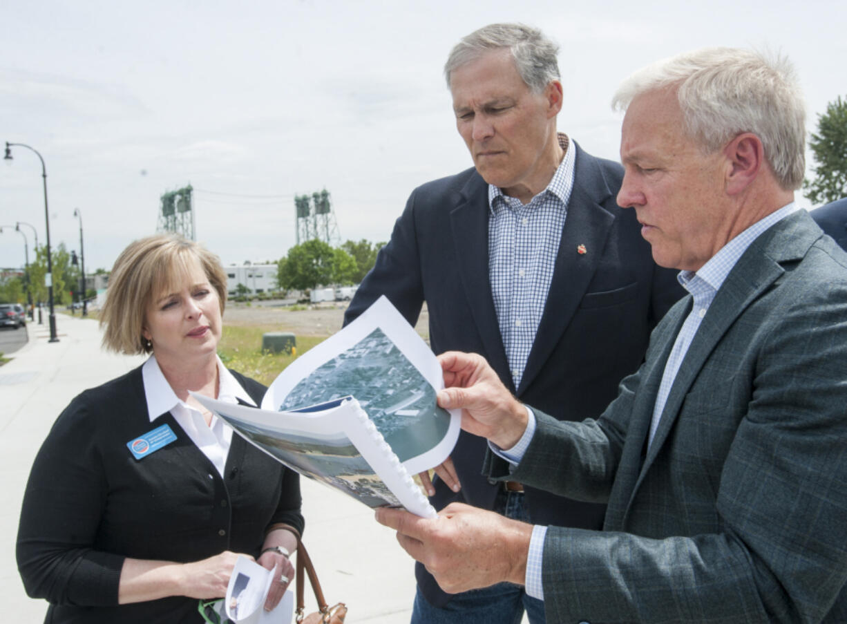 Gov. Jay Inslee, center, tours the future Vancouver waterfront park with the project&#039;s developer, Barry Cain, right, and Sen. Annette Cleveland, D-Vancouver, on Wednesday. Inslee said the project will benefit the entire state.