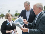 Gov. Jay Inslee, center, tours the future Vancouver waterfront park with the project&#039;s developer, Barry Cain, right, and Sen. Annette Cleveland, D-Vancouver, on Wednesday. Inslee said the project will benefit the entire state.