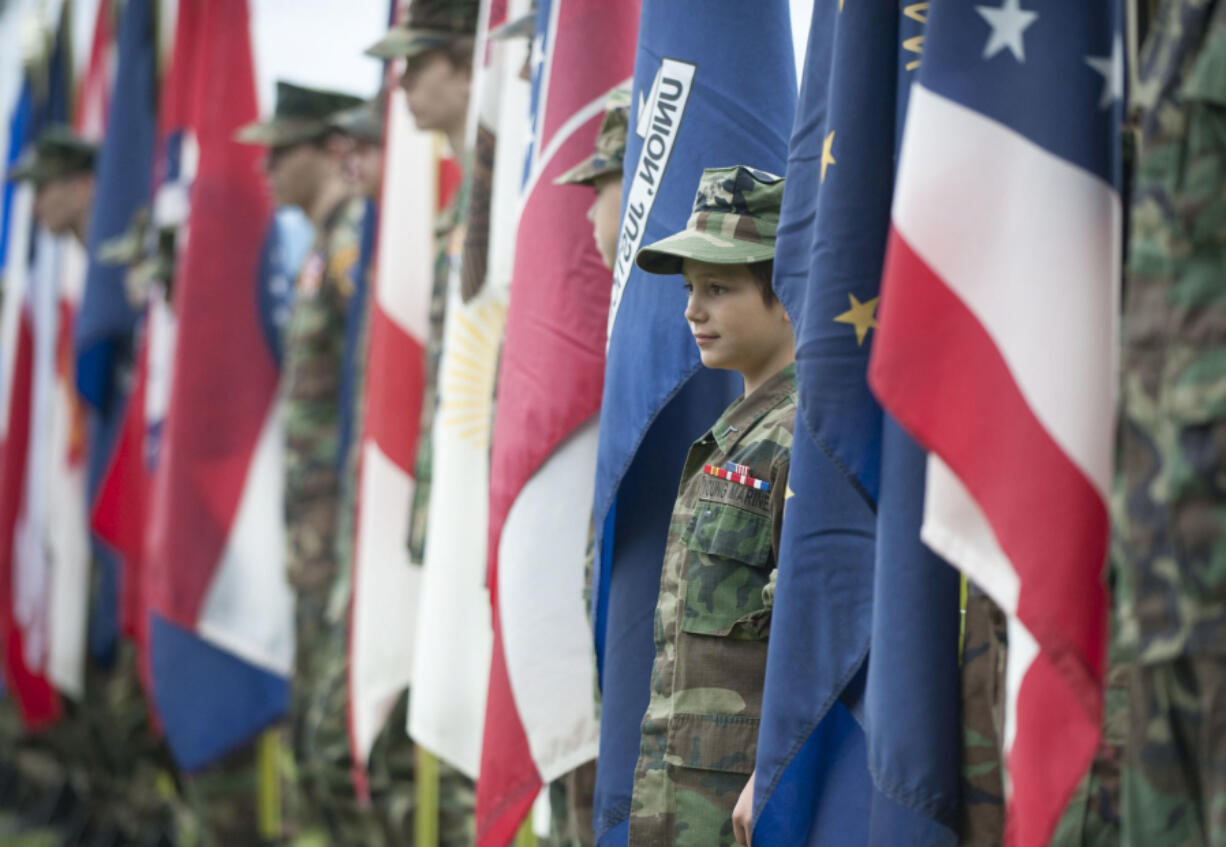 Brenden Pantazi of the Young Marines hold a flag as he and others participate in a Memorial Day ceremony at the Fort Vancouver National Historic Site in 2015.