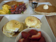 Eggs Benedict with fresh fruit, clockwise from foreground, are served with scrambled eggs, corned beef hash and pancakes on May 16 at Nayhely&#039;s Place in Hazel Dell.