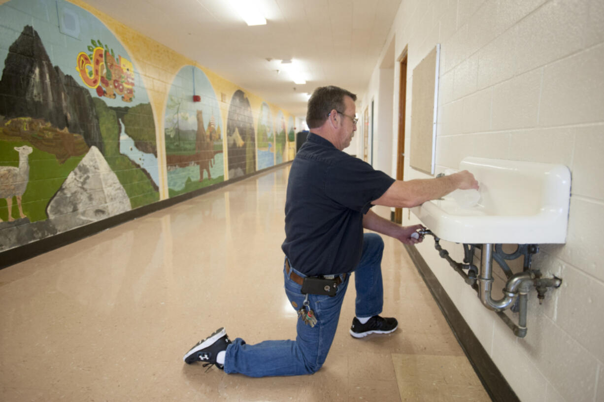 Joe Siler takes a sample of water to be tested for lead at Jason Lee Middle School on Wednesday morning. Vancouver Public Schools is among several Clark County school districts testing their drinking water for lead.