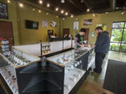 Budtender Alyssa Eng helps customer Mike Newhouse on May 20 at Main Street Marijuana&#039;s new location in east Vancouver. The shop joins a location in Uptown Village and in Longview as the store tries to create a &quot;regional presence,&quot; said owner Adam Hamide.