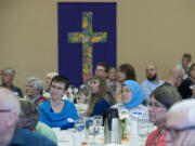 Adrienne Strehlow, pastor of Immanuel Lutheran Church, left, and Beth Sermet of the Islamic Society of Southwest Washington listen to speakers during the interfaith prayer breakfast Wednesday morning at Family of Christ Lutheran Church.