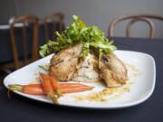 Roasted herb chicken is served at the Pioneer Street Cafe in Ridgefield. The dish includes a chicken prepared in lemon-herb sauce, with sides of mashed potatoes and candied carrots.