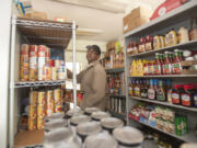 Baxter Jones sorts through canned goods Friday at Martha&#039;s Pantry, which was housed in the First Congregational United Church of Christ in Hazel Dell. The church was damaged by fire early Wednesday.