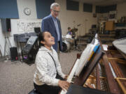 Student Oryann Fitim, 16, foreground, plays for Superintendent Dean Stenehjem on Monday afternoon at the Washington State School for the Blind. He is retiring at the end of the school year after 26 years at the helm of the state school.