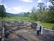 Jenny Stanton-Johnson, left, and her wife, Muriel Stanton-Johnson, stand where pig pens were in their storage barn and animal pavilion at Adeline Farms in Woodland. An April 27 fire that killed 11 animals destroyed it and hundreds of thousands of dollars of equipment.