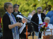 Pastor Jennifer Brownwell leads the congregation of the First Congregational United Church of Christ in prayer and song Wednesday evening as they gather in front of their church, which was damaged in a fire that morning.