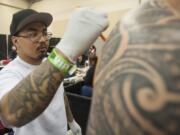 Tattoo artist AJ Tenoril draws an outline on the back of a customer Friday at Ink&#039;n the Couve Tattoo Convention at the Clark County Event Center in Ridgefield.