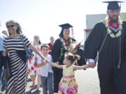 Jonas and Caitlin Calsbeek walk with their children, Jacob, 4, and Lily, 3, and Caitlin&#039;s mother, Brenda Tokuoa, to their car after the 2016 Washington State University Vancouver commencement ceremony at the Sunlight Supply Amphitheater on Saturday. The Calsbeeks, who are both Navy veterans, earned two degrees each.