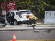 A fireman picks up an object at the scene of a crash on Milll Plain and Devine St.