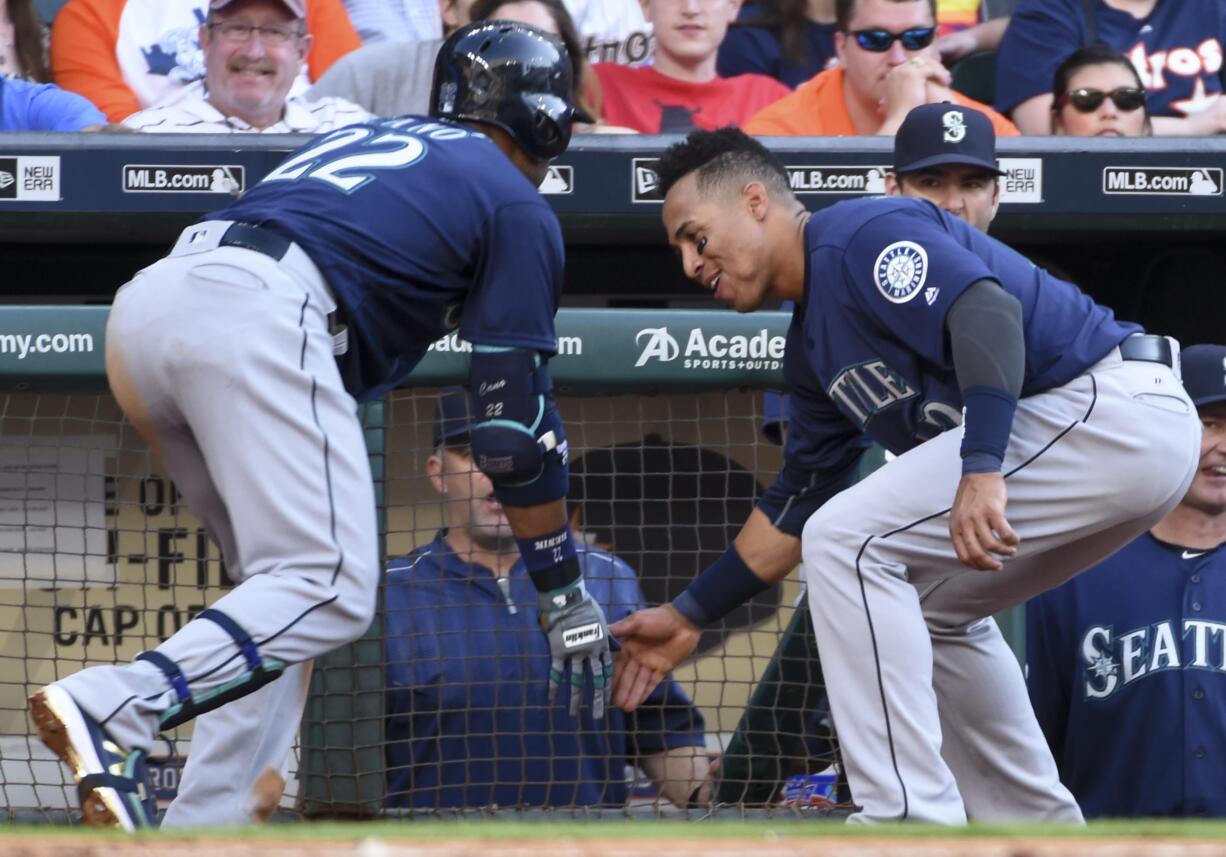 Seattle Mariners' Robinson Cano, left, celebrates his solo home run off of Houston Astros starting pitcher Dallas Keuchel with Leonys Martin in the third inning of a baseball game against the Houston Astros, Saturday, May 7, 2016, in Houston.