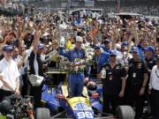 Alexander Rossi, center, celebrates after winning the 100th running of the Indianapolis 500 auto race at Indianapolis Motor Speedway in Indianapolis, Sunday, May 29, 2016.