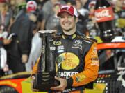 Martin Truex Jr. poses with the trophy after winning the NASCAR Coca-Cola 600 at Charlotte Motor Speedway in Concord, N.C., Sunday, May 29, 2016.