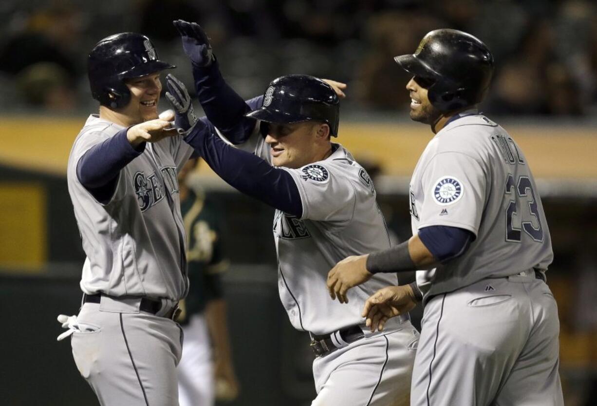 Seattle Mariners&#039; Kyle Seager, center, celebrates with Nelson Cruz (23) and Adam Lind, left, after hitting a three run home run off Oakland Athletics&#039; Marc Rzepczynski in the eighth inning of a baseball game Tuesday, May 3, 2016, in Oakland, Calif.