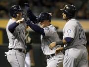 Seattle Mariners&#039; Kyle Seager, center, celebrates with Nelson Cruz (23) and Adam Lind, left, after hitting a three run home run off Oakland Athletics&#039; Marc Rzepczynski in the eighth inning of a baseball game Tuesday, May 3, 2016, in Oakland, Calif.