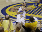 Fans cheer as Golden State Warriors guard Stephen Curry yells after the Warriors beat the Oklahoma City Thunder in Game 7 of the NBA basketball Western Conference finals in Oakland, Calif., Monday, May 30, 2016. The Warriors won 96-88.