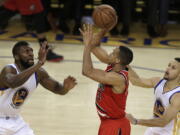 Portland Trail Blazers&#039; C.J. McCollum, center, shoots between Golden State Warriors&#039; Festus Ezeli, left, and Stephen Curry during the second half in Game 5 of a second-round NBA basketball playoff series, Wednesday, May 11, 2016, in Oakland, Calif.