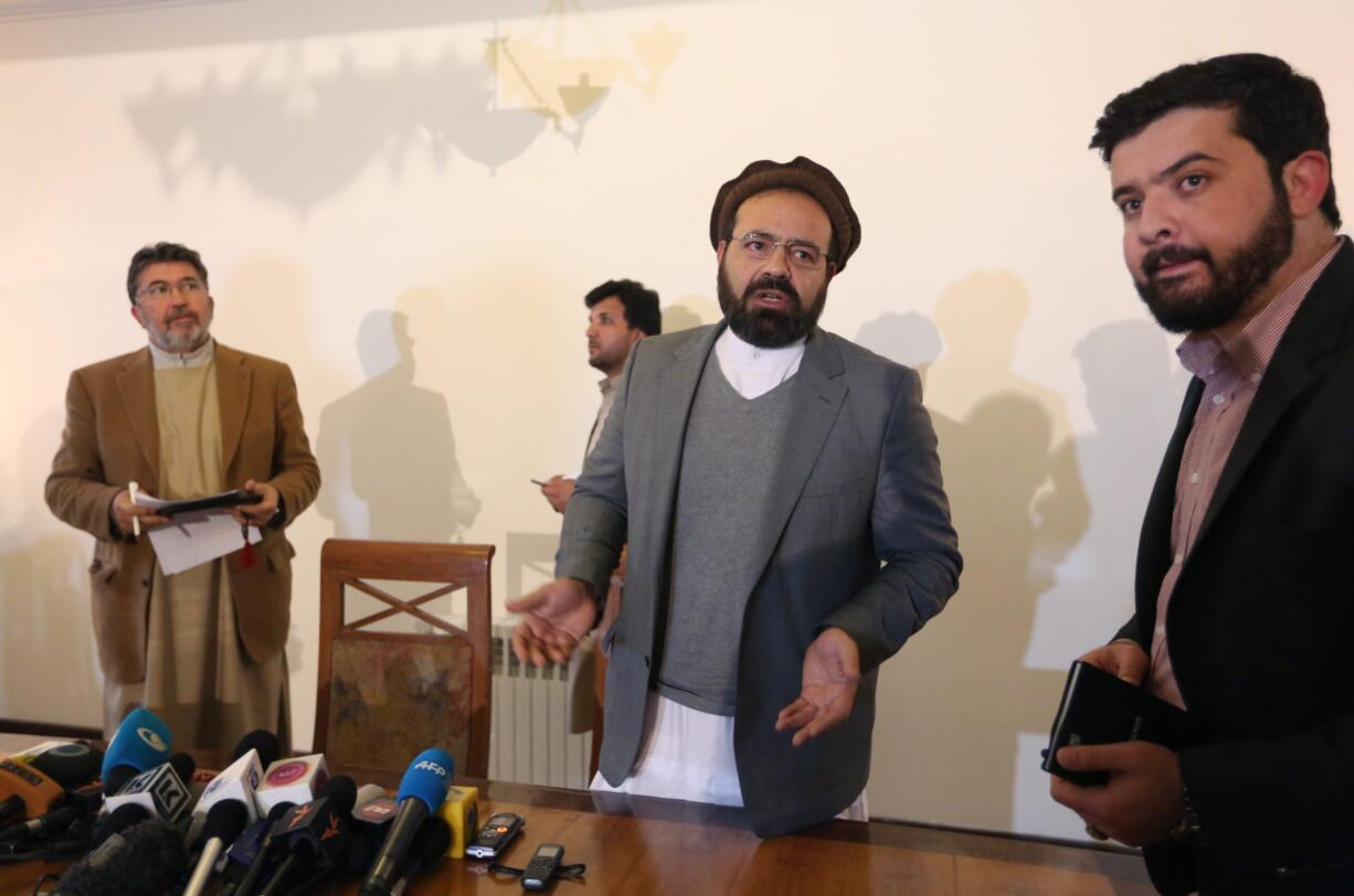 In this Thursday, March 17, 2016 photo, Amin Karim, second right, an official of the Hezb-i-Islami Party, speaks as he leaves after a press conference in Kabul, Afghanistan. An Afghan official says the government will finalize a peace deal with a notorious militant insurgent group within days. Ataullah Saleem, a deputy head of Kabul's High Peace Council, said on Saturday, May 14, an agreement with the armed wing of Hezb-i-Islami could be completed Sunday, after two years of negotiations.