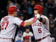 Los Angeles Angels' Albert Pujols (5) is greeted at home by Mike Trout on Pujols' three-run home run against the Seattle Mariners during the ninth inning of a baseball game Saturday, May 14, 2016, in Seattle.