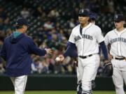 Seattle Mariners starting pitcher Taijuan Walker, second from right, is pulled in the eighth inning of a baseball game against the Oakland Athletics by Mariners manager Scott Servais, left, Monday, May 23, 2016, in Seattle. (AP Photo/Ted S.