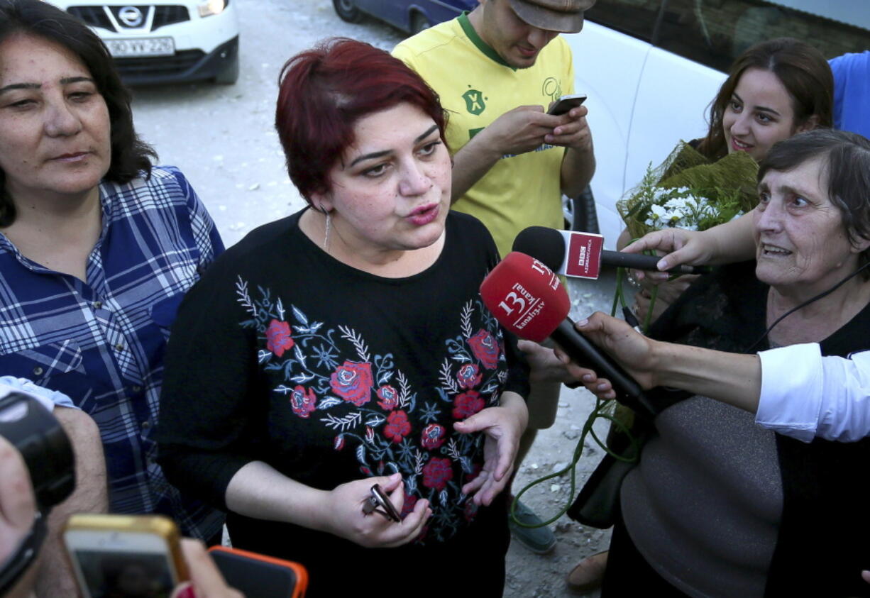 Khadija Ismayilova, center, a reporter for Radio Free Europe/Radio Liberty, speaks to journalists right after she was released from prison Wednesday in Baku, Azerbaijan.