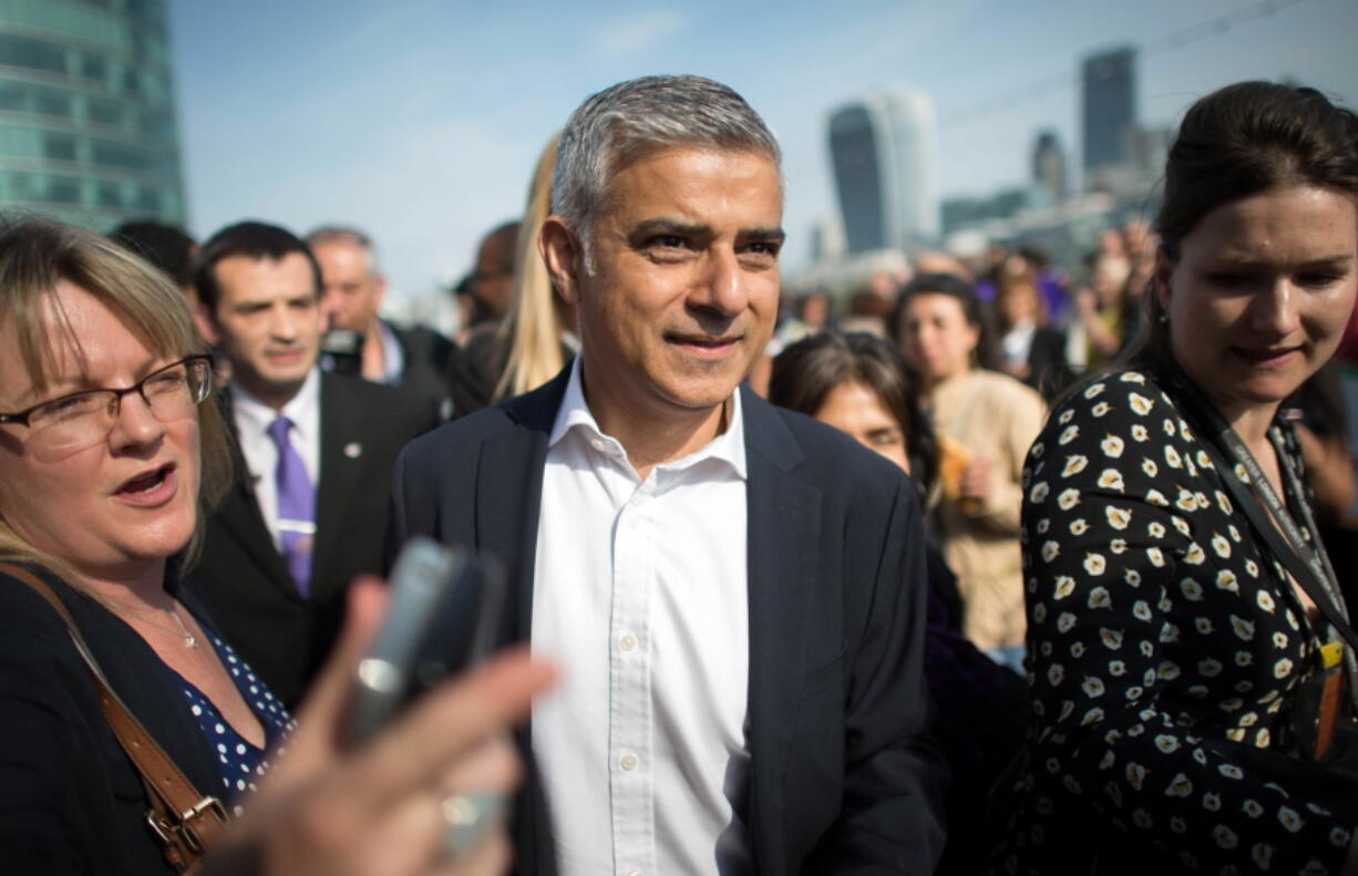 Newly elected London&#039;s mayor Sadiq Khan, center, is greeted by well wishers outside City Hall in London, on his first day as mayor Monday.