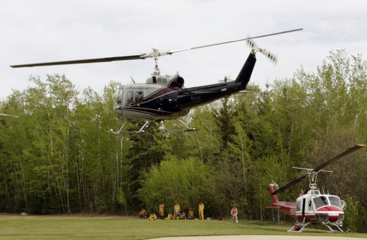 A helicopter carrying Agriculture and Forestry firefighters returning from a patrol mission takes off after refueling at a helipad in Lac La Biche, Alberta, on Saturday. The firefighters in Lac La Biche are focusing on recent wildfires that have broken out since the one at Fort McMurray.