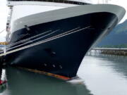 A whale carcass on the bow of a cruise ship is seen Sunday at a port in Seward, Alaska. A veterinary pathologist worked Monday to determine what killed the juvenile fin whale.