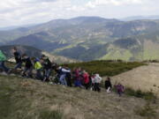 In this photo taken on Wednesday, May 11, 2016, tourists walk towards an artificial lake atop a mountain near the village of Loucna nad Desnou, Czech Republic. A pumped storage hydro plant featuring an artificial lake atop a mountain has turned into a top tourist site in the Czech Republic that?s about to welcome its millionth visitor.