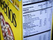 The nutrition facts label on the side of a cereal box is photographed in Washington. Nutrition facts labels on food packages are getting a long-awaited makeover, with calories listed in bigger, bolder type and a new line for added sugars. (AP Photo/J.