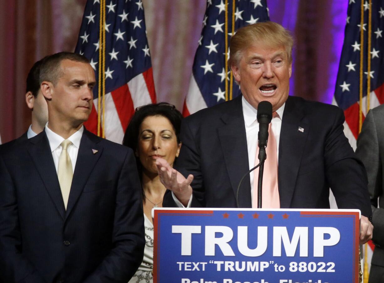 Donald Trump's campaign manager Corey Lewandowski listens at left as Trump speaks in March in Palm Beach, Fla.