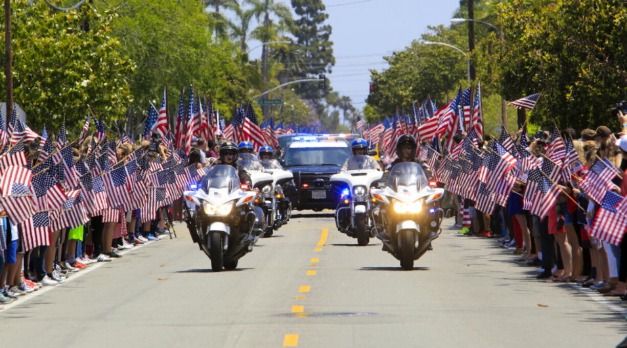 Coronado police and California Highway Patrol officers lead the funeral procession for Navy SEAL Charles Humphrey Keating IV, who was killed May 3 in Iraq, as it travels down Sixth Street on Friday in Coronado, Calif.