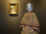 An Italian-made linen garden dress with hooded cape, made in 1865, is shown alongside a 19th Century painting from the Uffizi Gallery&#039;s Galleria di Arte Moderna collection depicting a similar style for a collateral show at Pitti Palace in Florence, Italy, organized as part of the &quot;Across Art and Fashion&#039;&#039; series of exhibits at locations throughout Florence. The exhibit opened Thursday as Italy&#039;s Renaissance capital is reclaiming its centuries-old role as an incubator of the fashion-art dynamic.