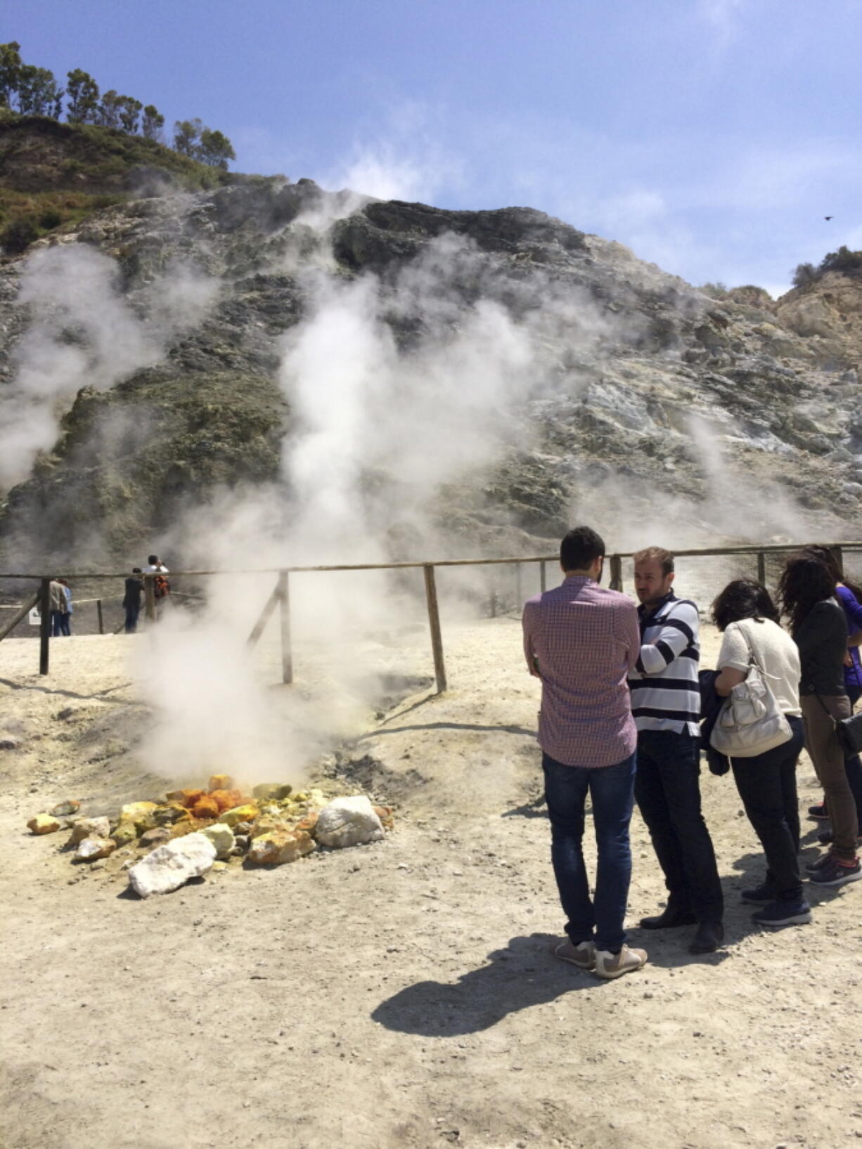 Visitors look at steaming fumarolas at the Solfatara Crater bed, in the Phlegraean Fields near Naples, Italy. In ancient times the site was believed to be the door to hell.