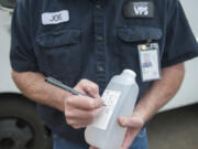 Joe Siler, a plumber who works for Vancouver Public Schools, takes a sample of water on May 4 at Jason Lee Middle School. The water was tested for lead.