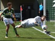 Portland Timbers goalkeeper Jake Gleeson makes a save as defender Chris Klute looks on during the second half of an MLS soccer game against Toronto FC in Portland, Ore., Sunday, May 1, 2016. The Timbers won 2-1.