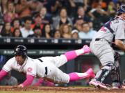 Houston Astros' George Springer, left, slides safely home past Seattle Mariners catcher Steve Clevenger on Carlos Correa's RBI-single in the seventh inning of a baseball game Sunday, May 8, 2016, in Houston.