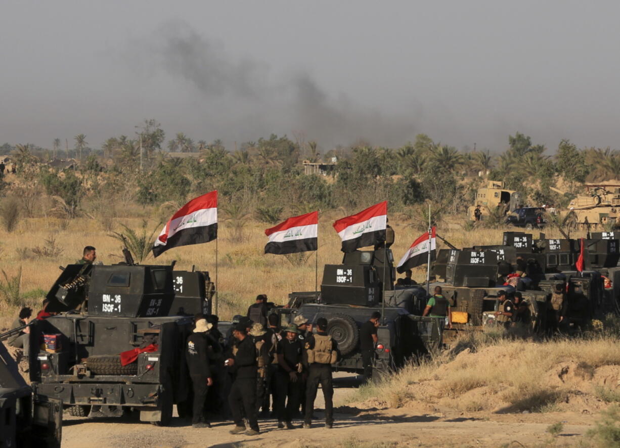 Smoke billows on the horizon as Iraqi military forces prepare for an offensive into Fallujah to retake the city from Islamic State militants in Iraqi on Monday. A wave of bombings claimed by the Islamic State group targeted commercial areas in and around Baghdad on Monday, killing more than 20 people in attacks that came as Iraqi troops poised to recapture Fallujah.