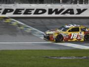 Kyle Busch (18) crosses the finish line to win a NASCAR Sprint Cup Series race at Kansas Speedway in Kansas City, Kan., Saturday, May 7, 2016.