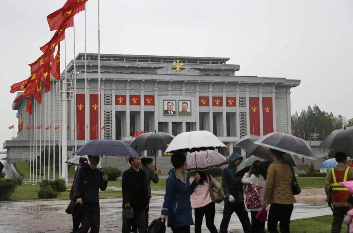 North Koreans carry umbrellas as they walk past the April 25 House of Culture, decorated in the colors and flags of their ruling party, the Workers&#039; Party on Thursday in Pyongyang, North Korea. Members of North Korea&#039;s ruling party have gathered in Pyongyang ahead of their biggest political conference in decades. Foreign experts say North Korea&#039;s leader Kim Jong Un will likely use the meeting to place his loyalists into key positions, strengthen his push to upgrade his country&#039;s nuclear arsenal and cement his grip on power.