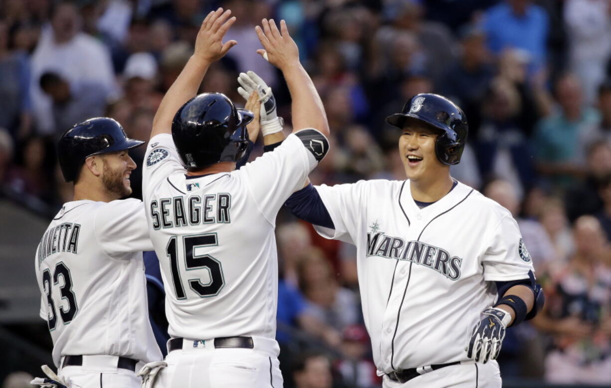 Seattle Mariners&#039; Dae-Ho Lee, right, is met at home by Chris Iannetta (33) and Kyle Seager (15) after his three-run home run against the Tampa Bay Rays during the fourth inning of a baseball game Tuesday, May 10, 2016, in Seattle.