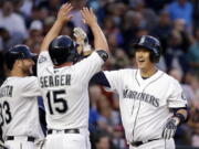 Seattle Mariners&#039; Dae-Ho Lee, right, is met at home by Chris Iannetta (33) and Kyle Seager (15) after his three-run home run against the Tampa Bay Rays during the fourth inning of a baseball game Tuesday, May 10, 2016, in Seattle.