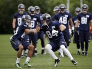 Seattle Seahawks' Doug Baldwin, left, and Cooper Helfet run through a drill at NFL football practice Thursday, May 26, 2016, in Renton, Wash.